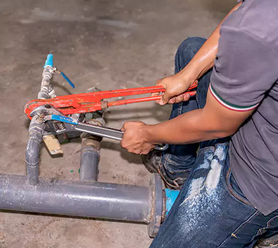 Licensed plumber repairing a copper pipe leak in a Kentucky basement
